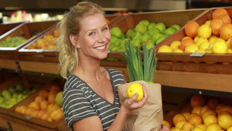 Smiling-blonde-with-paper-bag-picking-lemon