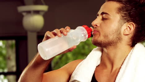 Fit-smiling-man-drinking-water