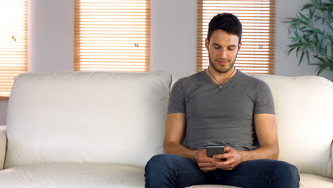 Man-sitting-down-and-using-his-phone