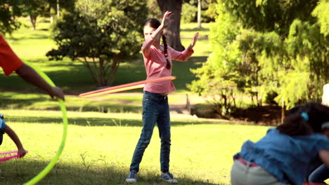 Little-friends-playing-with-hula-hoops-in-park