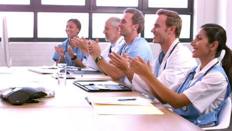 Smiling-medical-team-applauding-colleague