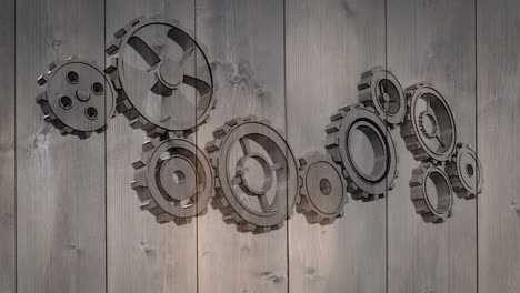 Cogs-and-wheels-turning-on-wooden-background