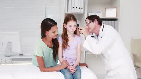 Doctor-examining-little-girl-with-her-mother