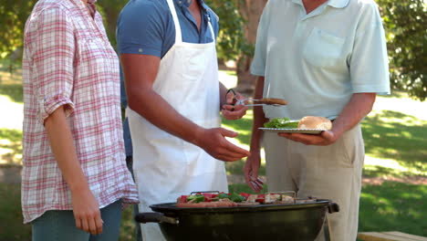 Hombre-Feliz-Haciendo-Barbacoa-Para-Su-Familia