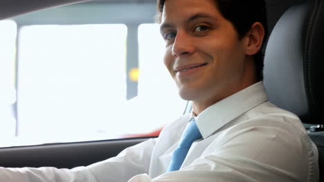 Smiling-businessman-sitting-in-a-car