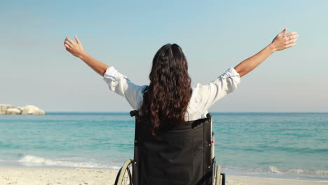 Disabled-woman-with-arms-outstretched-at-the-beach