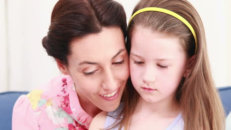 Mother-and-her-daughter-reading-a-book-on-couch