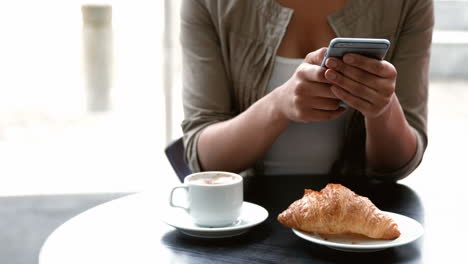 College-student-texting-at-campus-cafe