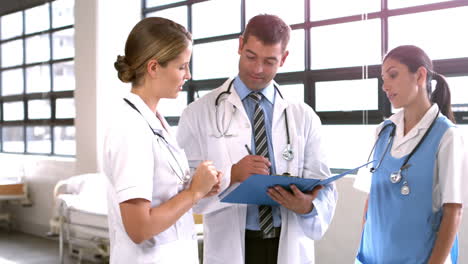 Medical-team-discussing-the-report-on-clipboard