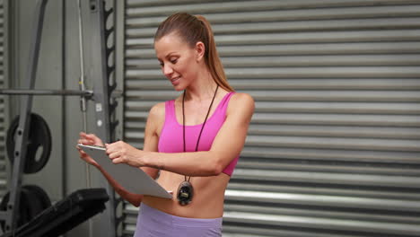 Trainer-taking-notes-at-crossfit-gym