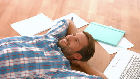 Happy-handsome-man-lying-on-floor-