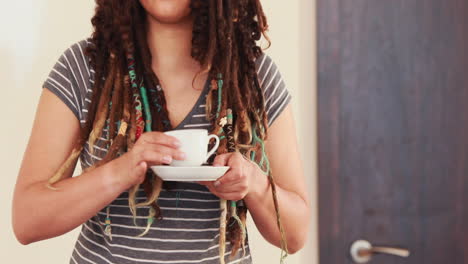Woman-with-dreadlocks-using-laptop-while-drinking-coffee