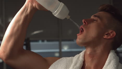 Fit-muscular-man-drinking-water-with-towel