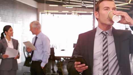 Businessman-with-smartphone-drinking-take-away-coffee