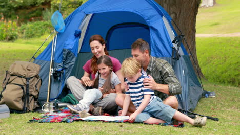 -Happy-family-on-a-camping-trip-in-front-of-their-tent