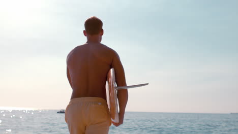 Hombre-Sosteniendo-Una-Tabla-De-Surf-Y-Corriendo-Hacia-El-Mar