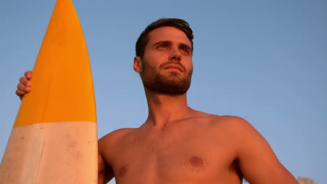 Hombre-Sin-Camisa-Con-Una-Tabla-De-Surf-Mirando-Hacia-La-Playa