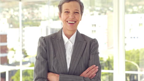 Happy-businesswoman-smiling-at-camera-with-arms-crossed