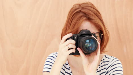 Smiling-hipster-woman-taking-picture-with-camera