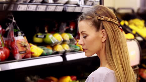 Young-smiling-woman-looking-at-vegetables