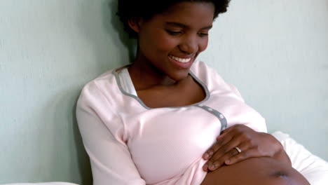 Schwangere-Frau-Sitzt-Auf-Dem-Bett-Und-Berührt-Ihren-Bauch
