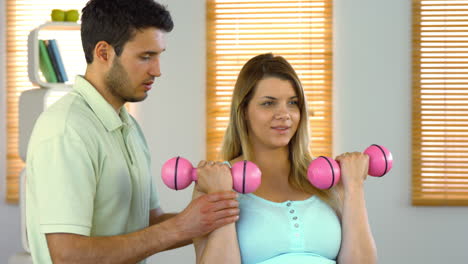 Mujer-Embarazada-Haciendo-Ejercicio-Con-Instructor