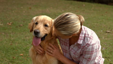Happy-blonde-woman-with-her-dog-in-the-park-