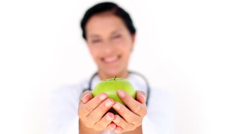 Confident-female-doctor-holding-green-apple