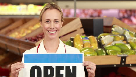 Smiling-worker-holding-open-sign-