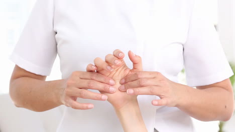 Physiotherapeutin-Untersucht-Die-Hand-Ihrer-Patientin