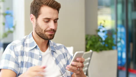 Hombre-Guapo-Usando-Su-Teléfono-Inteligente-Y-Tomando-Café