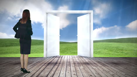 Door-opening-to-green-meadow-watched-by-businesswoman