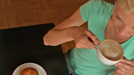 Pretty-blonde-having-coffee-and-bagel-in-cafe