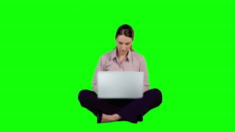 Businesswoman-using-laptop-against-green-screen