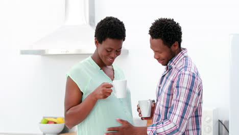 Pregnant-couple-drinking-coffee-in-the-kitchen