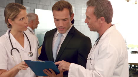 Doctors-discussing-the-report-on-clipboard