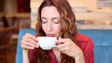 Woman-sipping-on-a-cappuccino