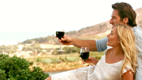 Couple-looking-far-away-with-red-wineglasses-in-slow-motion