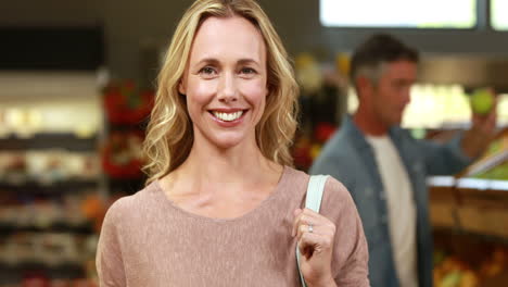 Smiling-blonde-holding-basket-with-vegetables