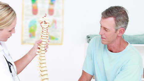 Doctor-explaining-anatomical-spine-to-her-patient-