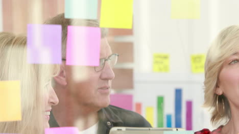 -Businessman-writing-on-post-it-with-his-colleagues