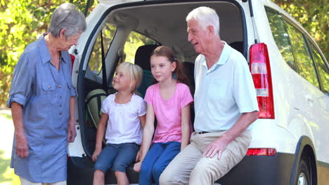 Happy-family-sitting-on-car-boot