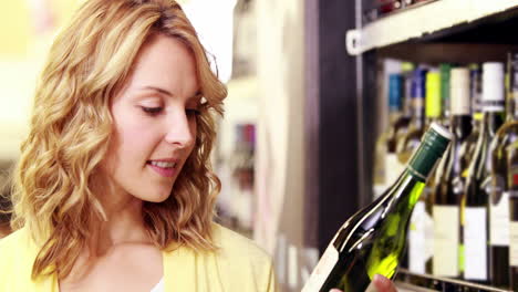 Young-happy-woman-smiling-at-camera-with-wine-in-her-hands