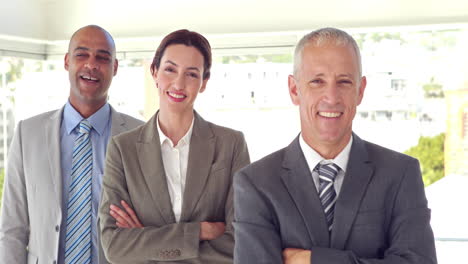 Business-people-smiling-at-camera-with-arms-crossed