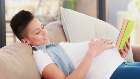 Pregnant-woman-reading-a-book-while-lying-on-the-couch