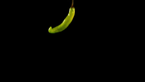 Chili-peppers-falling-on-black-background