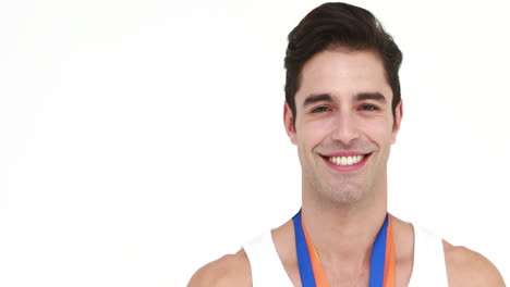 Smiling-athlete-kissing-medal-and-showing-thumb-up