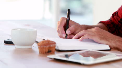 Hands-of-casual-business-man-writing-on-paper-