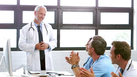 Smiling-medical-team-applauding-colleague