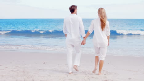 Happy-couple-walking-on-the-beach